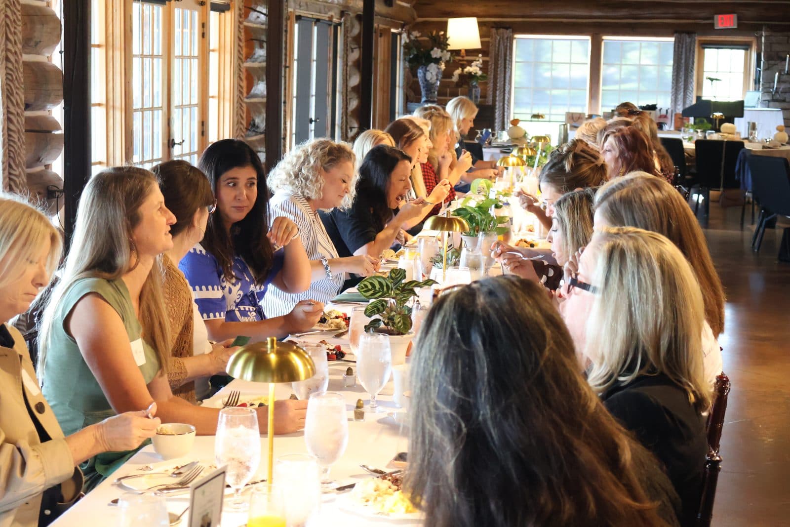 Women talking and laughing over brunch at the Gather and Grow Retreat